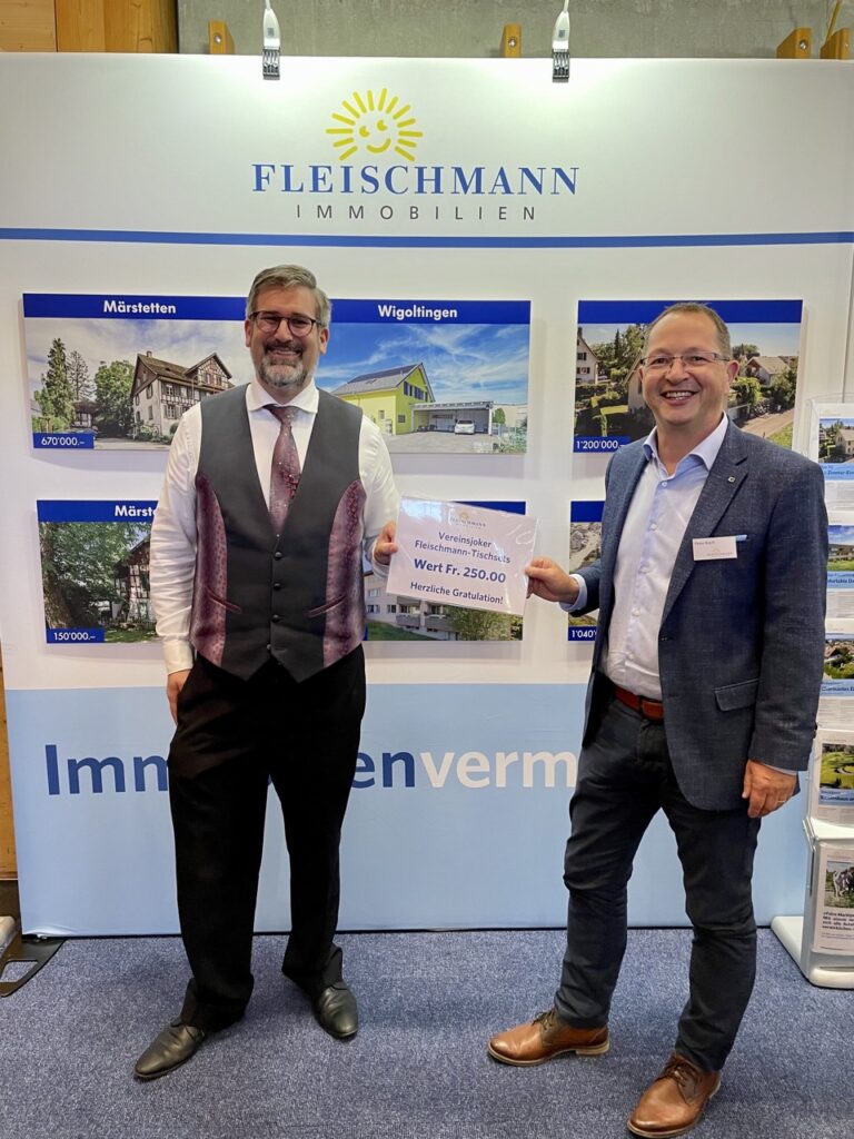 Liegenschaftsexperte Peter Koch von Fleischmann Immobilien (rechts) überreicht Patrick Spiri, Präsident der Musikgesellschaft Märstetten, den «Jokerpreis» der Tischset-Sponsoringaktion.